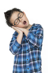 Little child in glasses feels sleepy on isolated white background with blue shirt