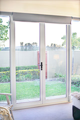 Fototapeta na wymiar Glass door entrance with green grass garden view