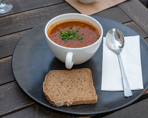 Goulash served in tea cup viewed from an angle served with bread