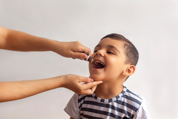 Child immunization with little drop in clinic. Doctor providing immunization vaccines. Little boy...