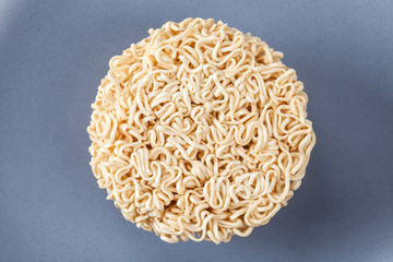 Close up Raw Instant noodles isolated on a gray plate with space for copy.