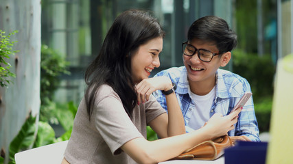 Lovely young couple used smartphone and talking together