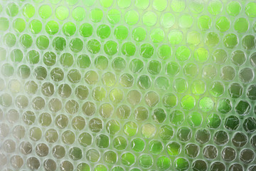 Fototapeta premium translucent white plastic bubble wrap texture on green color blur background