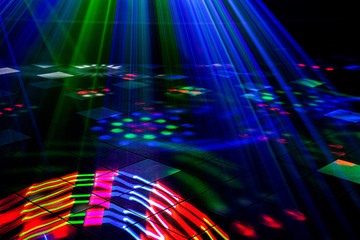 Bright nightclub red, green, purple, white, pink, blue laser lights cutting through smoke machine smoke making light and rainbow patterns on the dance floor with bokeh in the background. Mardi Gras