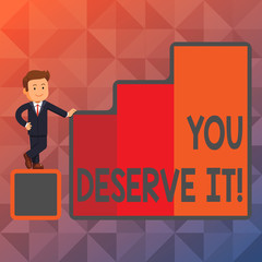 Text sign showing You Deserve It. Business photo showcasing should have it because of their qualities or actions Happy Businessman Presenting Growth and Success in Rising Bar Graph Columns
