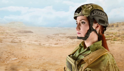 Side view portrait of young and beautiful US military soldier woman in helmet on desert background with space for text.