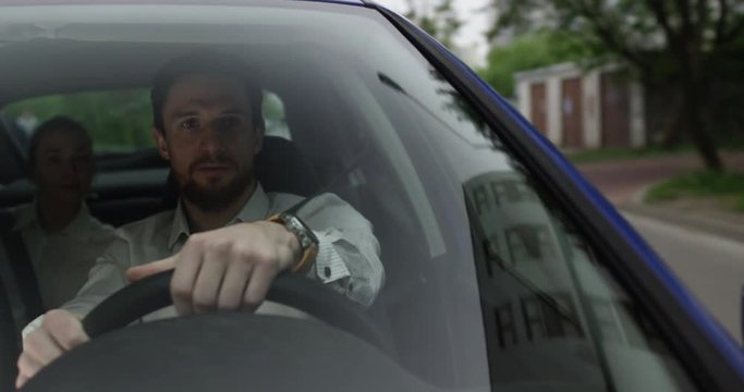 Male uber driver talks to his passenger inside the car