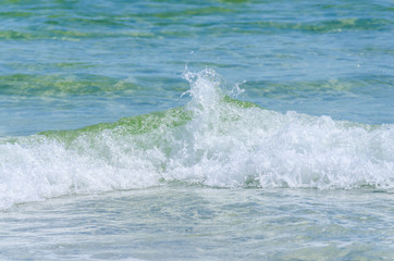 Naklejka premium Tropical ocean waves splashing. Scenic tourist travel destination location for vacation and relaxation. Warm blue green waves crashing and coming to shore