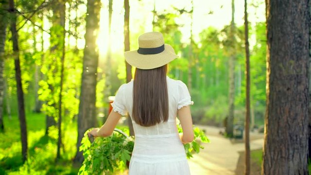 Young romantic beautiful traveler woman girl with hat and white dress with retro vintage bicycle in sunset forest. Riding on bike with basket of flowers. spring summer time nature park. Happy holiday