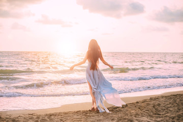 mysterious mermaid with long black hair slowly walks in water of ocean, sea nymph listens to wind...
