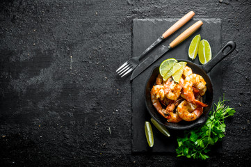 Fragrant shrimps on a stone Board with parsley and lime.
