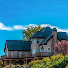 Obraz premium Square House with balcony overlooking snow capped mountain and blue sky on a sunny day