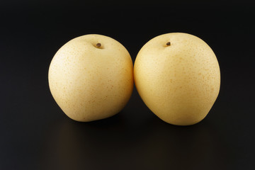 Two sand pear fruit isolated on black background
