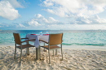 Table outdoor next to sea scenic prepare for special romantic dinner time.