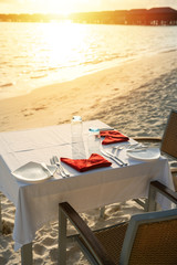 Table outdoor next to sea scenic prepare for special romantic dinner time with sunlight shading..