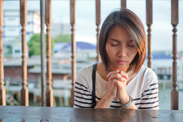woman praying in morning, hands folded in prayer