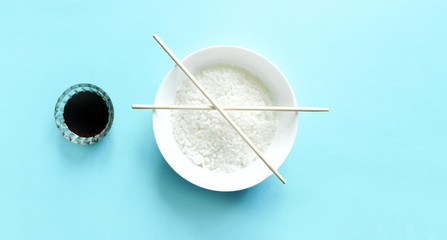 Traditional Bowl of rice and chopsticks isolated on blue. Asian cuisine.Healthy food concept.top view, flat lay.