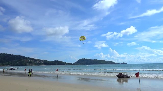 Parasailing in Patong beach, famous beach full of tourists from around the world, located in Phuket, Thailand.