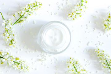 Daily  face cream.Organic natural cosmetic product .Jar with cream and flowers on white background. Woman's skincare routine. Beauty blogger flat lay concept.Place for your text or logo.