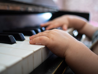 Hands of a small child playing the piano keys