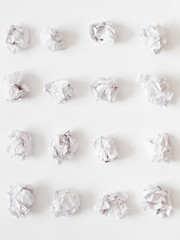 Waste reduction. Flat lay of crumpled paper ball rows on white surface. Abstract background.