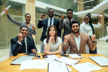 Asian business person in multiracial. Diversity business people form by different races, Indian, Malay, Indonesian, Chinese and African documents throwing paper up in modern room