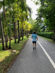 Middle aged man in blue polo shirts and black pants, jogging Exercise in the health garden