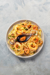 Seafood pasta. An overhead photo of a plate of tagliolini with mussels, shrimps, clams and squids, with copyspace