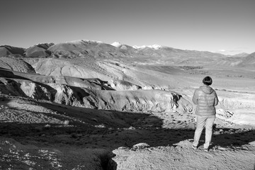 Happy woman standing on rock. Mars mountains, the name of colored mountain protrusions in the mountains of Kyzyl-Chin. Altai, Russia. A delightful landscape of unreal beauty.