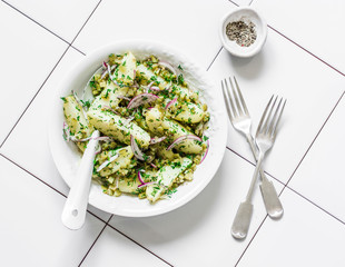Young potatoes, gherkins, red onions, french mustard olive oil dressing salad on a light...