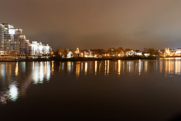 Traetskae Pradmestse or Trinity Suburb and Island of Courage and Sorrow or Ostrov Slyoz on Svisloch river bank at night. Minsk. Belarus