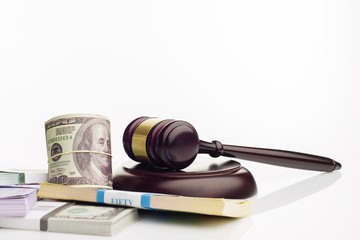 Judge's gavel and packs of dollars and euro banknotes on a white background