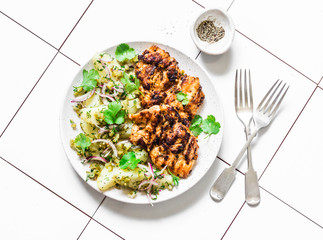 Delicious lunch - grilled chicken fillet and  dill, cilantro new potatoes salad on light...