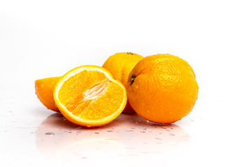 Naklejka na ściany i meble isolated on a white sprinkled water background, fresh, juicy orange fruits