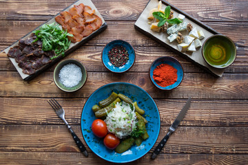 A bowl with pickles and spices on a wooden background.