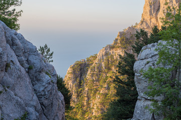 cliffs of Mount Ai-Petri in the Crimea, lit by the sun at dawn, in the background the blue sea