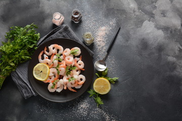 Fresh prawns. Raw shrimps, prawns in a plate on a dark background. Seafood. 