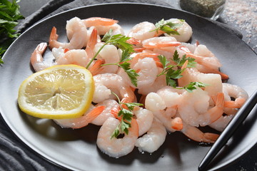 Fresh prawns. Raw shrimps, prawns in a plate on a dark background. Seafood. 