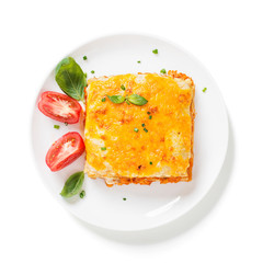 Portion of tasty chicken lasagna with cheddar cheese and bechamel sauce isolated on white background.
