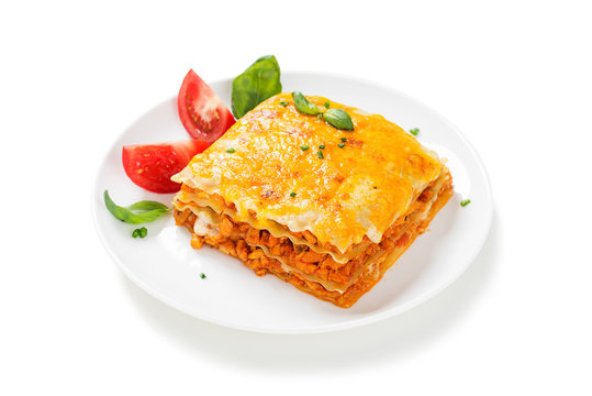 Portion of tasty chicken lasagna with cheddar cheese and bechamel sauce isolated on white background.