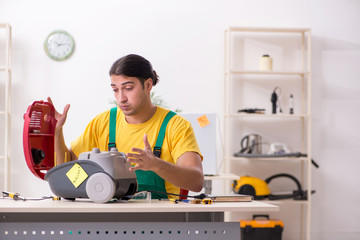 Man repairman repairing vacuum cleaner 