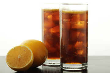 Glasses with cuba libre cocktail or cola with ice or cold tea with lemon