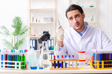 Young male chemist working in the lab 