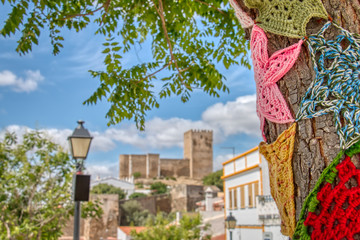 Trees decorated with colorful crochet patchwork on a holiday in the town of Mertola, a very beautiful city in the Portuguese Alentejo area