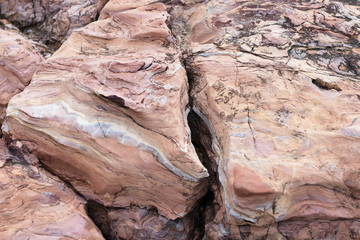 The rock is red with a rift. The crack in the stone, a piece of a broken stone brown color. Red stone with streaks of other colors. America canyon. Similiar