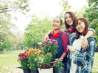 Beatiful three Woman Gardeners family are growing flowers in pots.