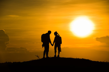Fototapeta na wymiar Silhouette couple on the mound in the sunset sky