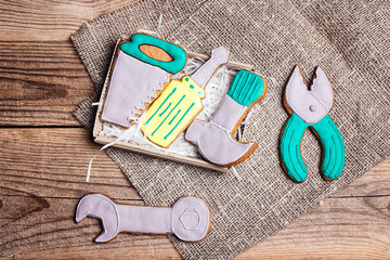 A set of gingerbread in the form of hand tools on a burlap on a wooden table. Tasty creative...