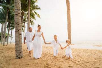 Happy young family on the sunset at the beach.