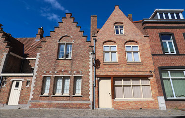 Scenic city view of Bruges canal with beautiful medieval colored houses .